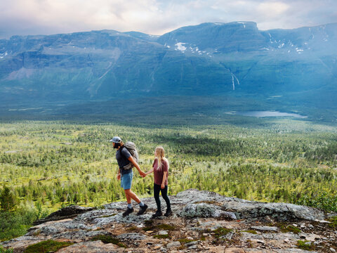 Couple travel in northern Norway friends hiking together man and woman explore Scandinavian mountain trails, adventure summer romantic vacations healthy lifestyle tour family holidays eco tourism