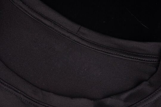 Editable close-up mockup of a fitted black t-shirt featuring a screen-printed logo at the collar.