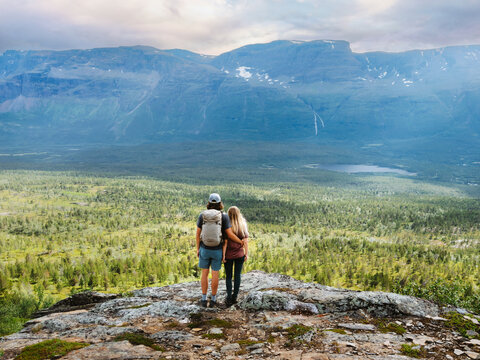Couple in love hugging on the mountain top travel together romantic vacations trip in northern Norway adventure family lifestyle, friends man and woman hiking explore Troms trails bonding moments