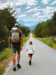 Fototapeta na wymiar Family dad and child on hiking vacations in Norway parent and kid explore trails outdoors walking together to the mountains, father and daughter on adventure summer activity backpacking trip