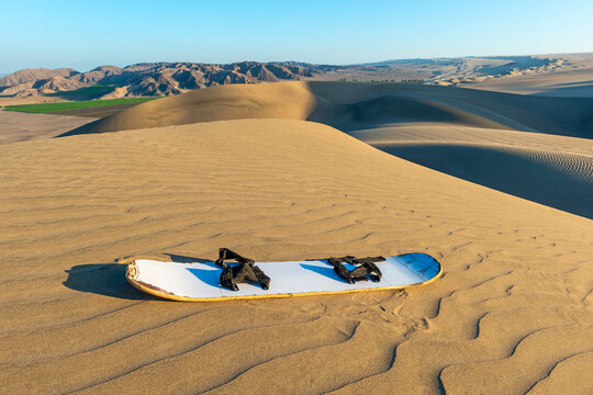 Sandboard at sunset in the Nazca desert near Ica, Peru.