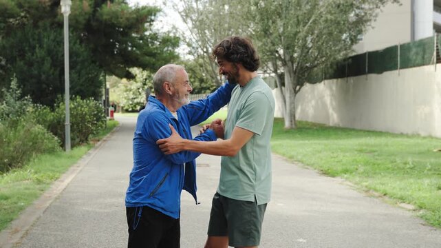 Senior father and adult son celebrating sport success highfive hug showing complicity