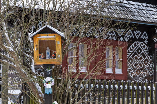 Wayside shrine statue in Cicmany with painted house