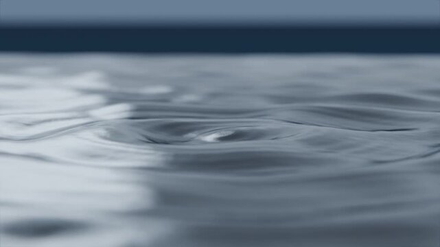 Falling droplets striking water surface, creating crown and ripples across water with horizon band