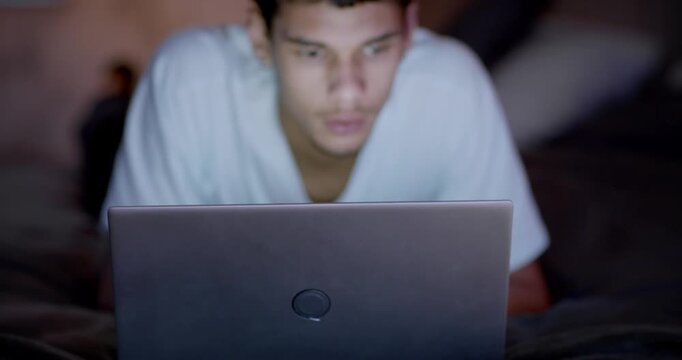 African American man watching laptop on bed, lifting head as logo fills frame, reacting to clip