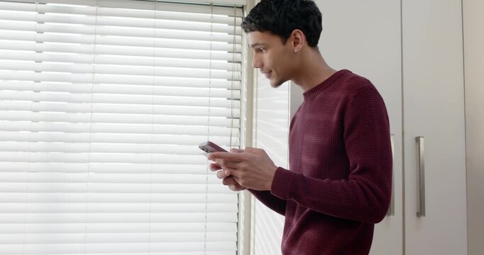 African American man holding phone, reading message, reacting toward horizontal blinds, copy space