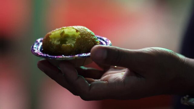Hand Holding Crispy Golgappa Filled with Pani Puri Water &ndash; Popular Indian Street Food, night light footage