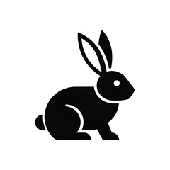 Fototapeta premium Sitting rabbit icon with long upright ears, round body, short front legs and small tail in a bold black animal silhouette isolated on white