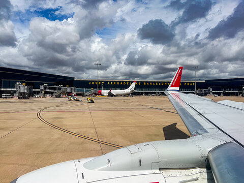 Barcelona, Spain; September 6 2024: Airplane wing waiting for takeoff at josep tarradellas barcelona-el prat airport with cloudy sky