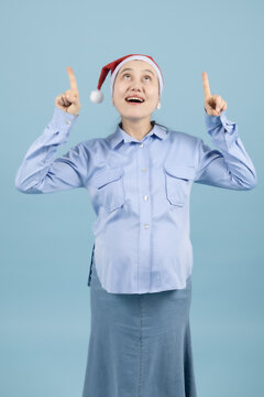 Young woman pointing fingers upwards with a surprised facial expression