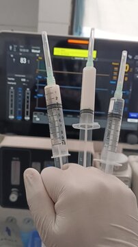 Close-up of nurse holding liquid anesthesia syringes in operating room