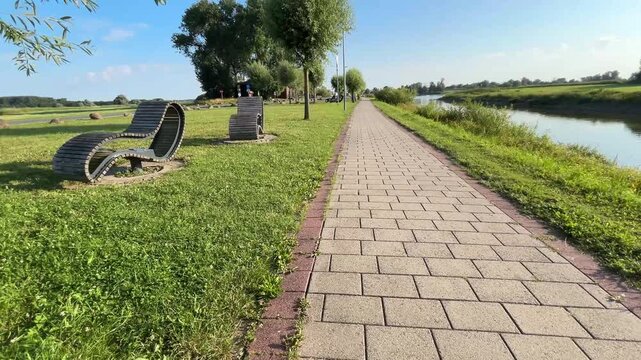 Sunny Riverside Promenade with Walking Path Along Waterfront, Slow Camera Movement, 4K UHD
