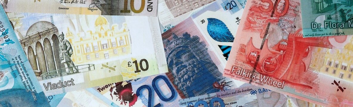 Scottish pound money bills in pile on table. Scotland GBP currency cash close up
