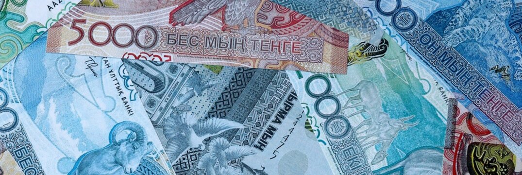 Kazakhstani tenge money bills in pile on table. Kazakhstan KZT currency cash close up