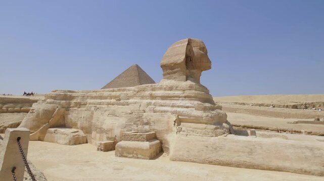 The Great Sphinx of Giza with the Pyramid of Khafre in the background under a clear blue sky, showcasing Egypt&rsquo;s iconic ancient monuments and timeless desert landscape.