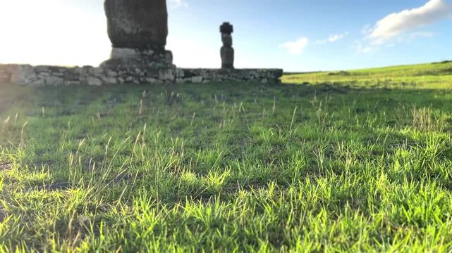  Ahu Tahai ceremonial complex on Easter Island, Chile. Historic Moai statues overlooking the Pacific Ocean on the sunset with scattered clouds.