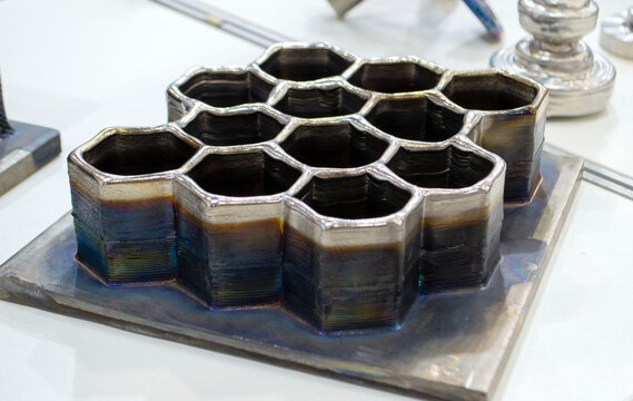 Metal model of a honeycomb structure created using 3D printing. Additive manufacturing. Metal alloy. Object printed on 3D printer from metal. Layer-by-layer deposition of metal thread. 3D printing