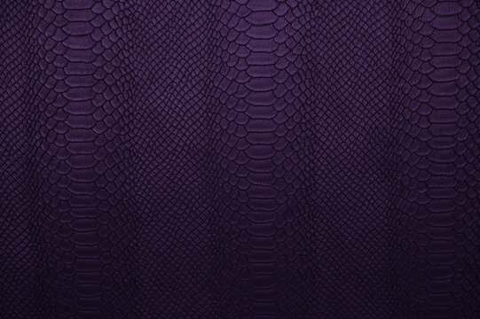 Deep purple dyed crocodile skin surface on synthetic fabric