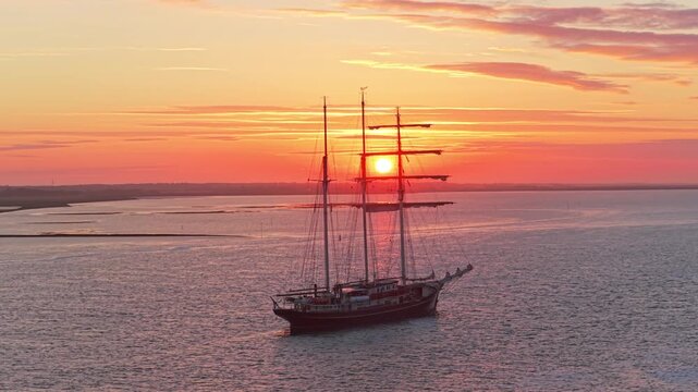 Tall ship gulden leeuw sailing on the wadden sea at sunset in terschelling