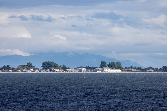 Tsawwassen Coastal Waterfront Panorama With Ocean, Beach Houses and Cloudy Mountain Backdrop in British Columbia