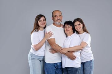Fototapeta premium Happy family. Twin sisters and their parents on grey background