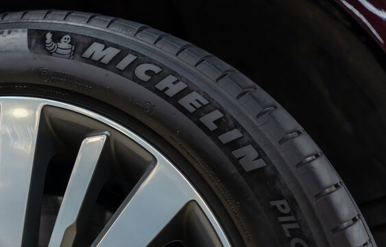 Michelin Pilot sport performance tire mounted on a modern alloy wheel of a luxury passenger car closeup view. High quality automotive rubber product black sidewall texture with corporate brand. 