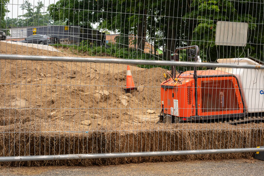 Construction Site with Orange Machinery behind Wire Fence