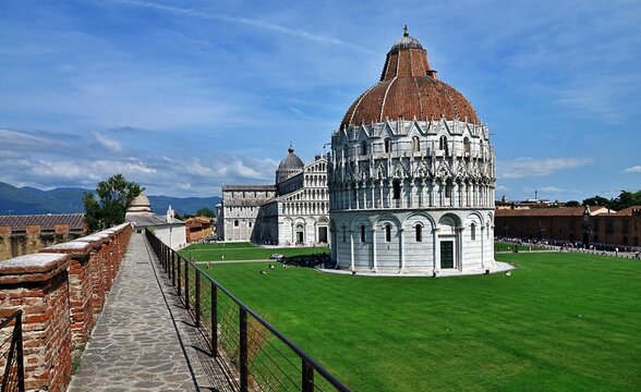 Pisa, Tuscany, Italy - 02.06.2025: The historic Piazza dei Miracoli in Pisa, Italy, showcases stunning Romanesque architecture with the baptistery in the foreground and the cathedral behind it