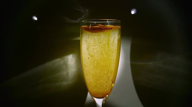 Dry turmeric powder slowly dissolving and sinking to the bottom of a water glass on a dark background
