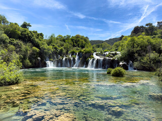 Naklejka premium Bottom pool of waterfalls and cascade mountain river running through the forest during late spring