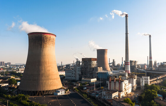 Wuhan Thermal Power Plant featuring gaint nuclear-style cooling towers and smokestacks, emitting heavy steam. It uses ultra-low emission, cogeneration for green energy transition. China.	