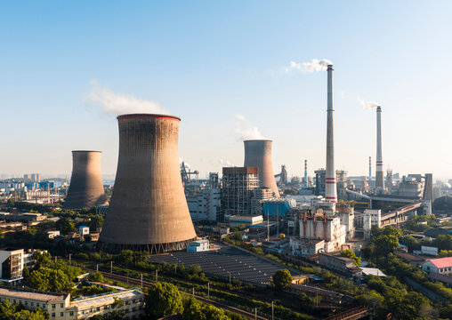 Wuhan Thermal Power Plant featuring gaint nuclear-style cooling towers and smokestacks, emitting heavy steam. It uses ultra-low emission, cogeneration for green energy transition. China.	