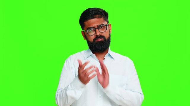 Indian man nods head with a friendly smile, expressing agreement and approval with confident positive energy. Arabian guy isolated on green chroma key background showing consent and supportive gesture