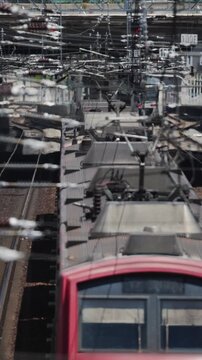 Train arrives at busy station during midday rush hour in urban area