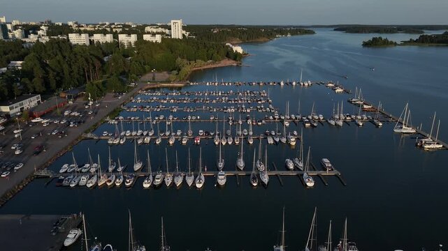 Drone flies above marina with rows of moored boats and parallel piers creating striking geometric composition on calm water