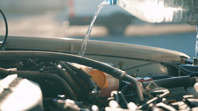 Man Missing Windshield Washer Fluid Reservoir While Pouring Water | Spilling Liquid Over Car Engine Bay | Vehicle Maintenance Mistake Outdoor