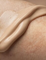 Fototapeta premium Silky cosmetic cream texture spread across natural skin in macro close up