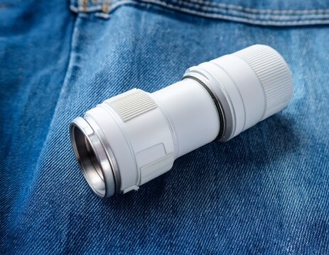 white plastic camera lens mount adapter on blue denim fabric