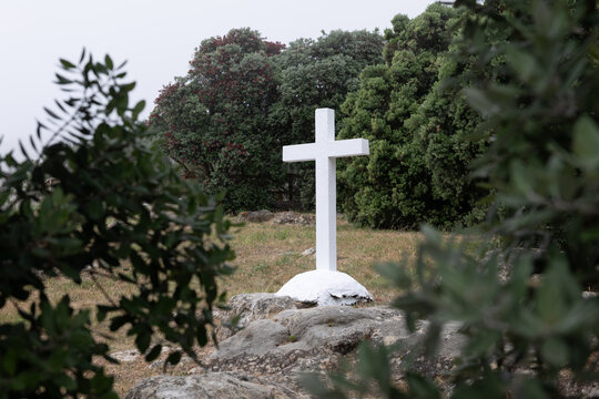 White christian cross standing on rocky ground