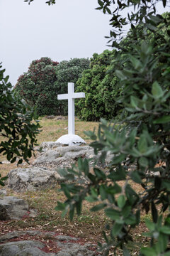 White christian cross standing on rocky hill