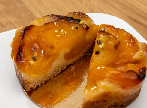 Brittany artisan bakery apricot tart with thinly sliced, caramelized apricots on buttery pastry with glossy glaze; sweet, French breakfast in bakery