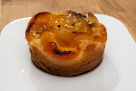 Brittany artisan bakery apricot tart with thinly sliced, caramelized apricots on buttery pastry with glossy glaze; sweet, French breakfast in bakery