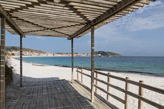 Wooden pergola boardwalk leading to a white sand beach