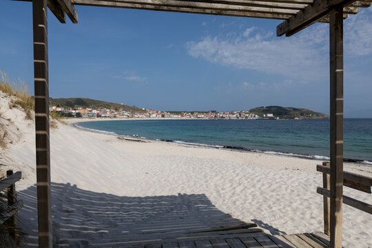 Wooden pergola framing beach, sand dunes, and coastal town