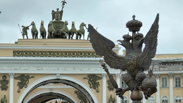 Saint Petersburg, Russia - August 25, 2022: The double-headed (three-headed) eagle - an element of the fence of the Alexander Column - against the background of the General Staff building 