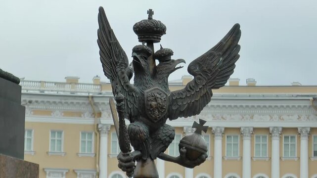 Saint Petersburg, Russia - August 25, 2022: The double-headed (three-headed) eagle - an element of the fence of the Alexander Column - against the background of the General Staff building 