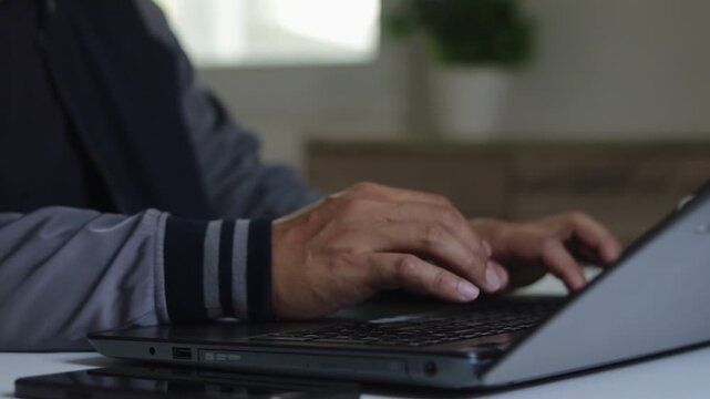 Closeup of man hand typing on laptop keyboard in modern workspace, productivity, remote work, digital communication, technology use and online business lifestyle in contemporary office environment.