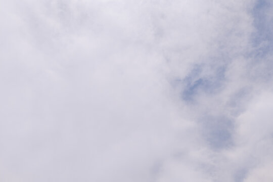 Blue sky peeking through soft white clouds
