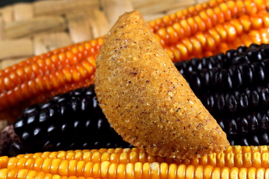 Cornmeal mush pastry served on ears of corn of various colors.