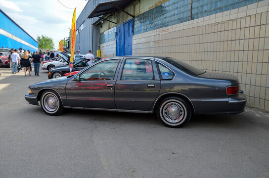 Classic dark grey metallic Chevrolet Caprice sedan a full size American cruiser from the 1990s on display at an outdoor automotive festival